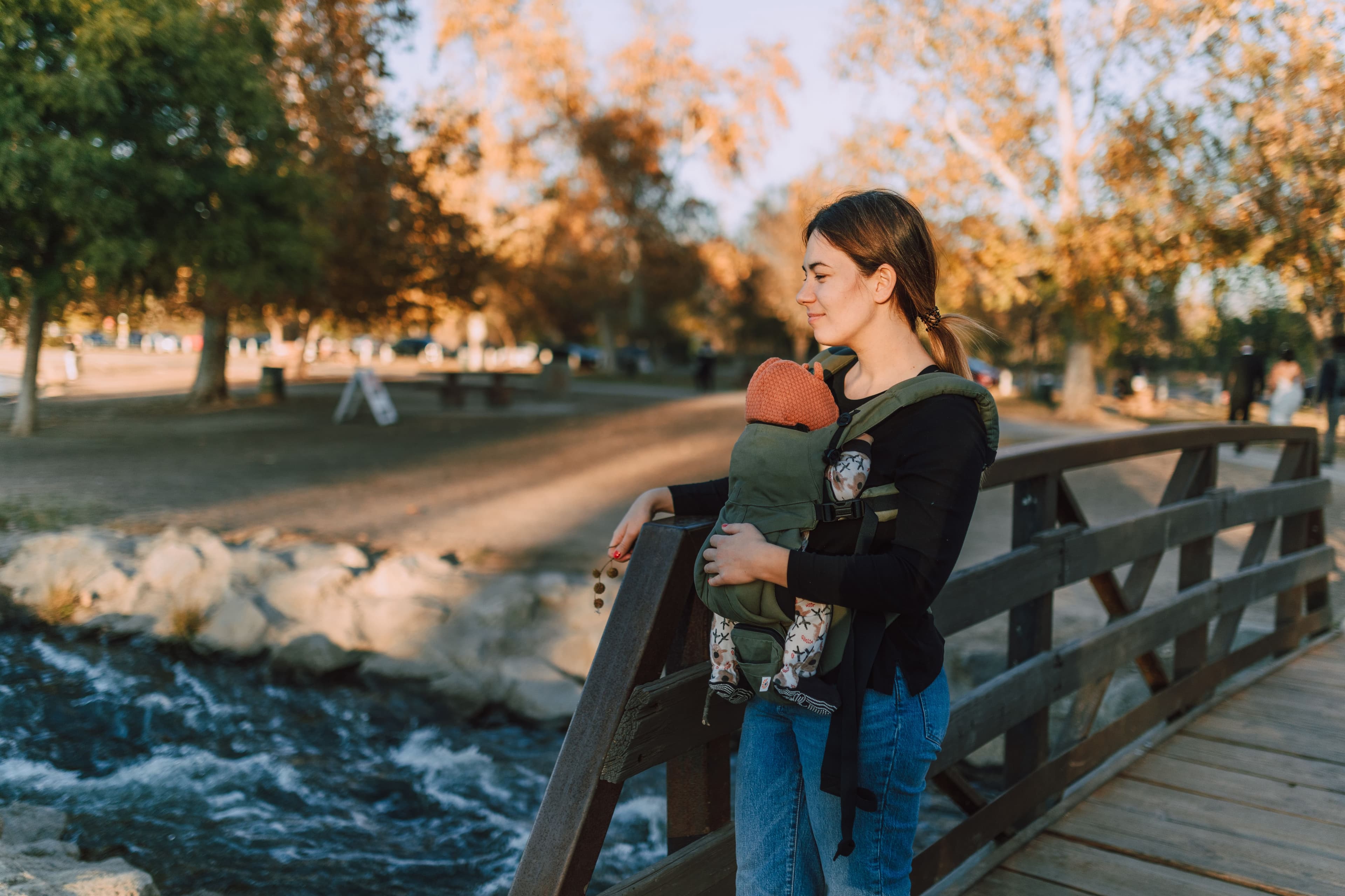 Parent wearing a baby in an ergonomic carrier — BabyCosts Australia