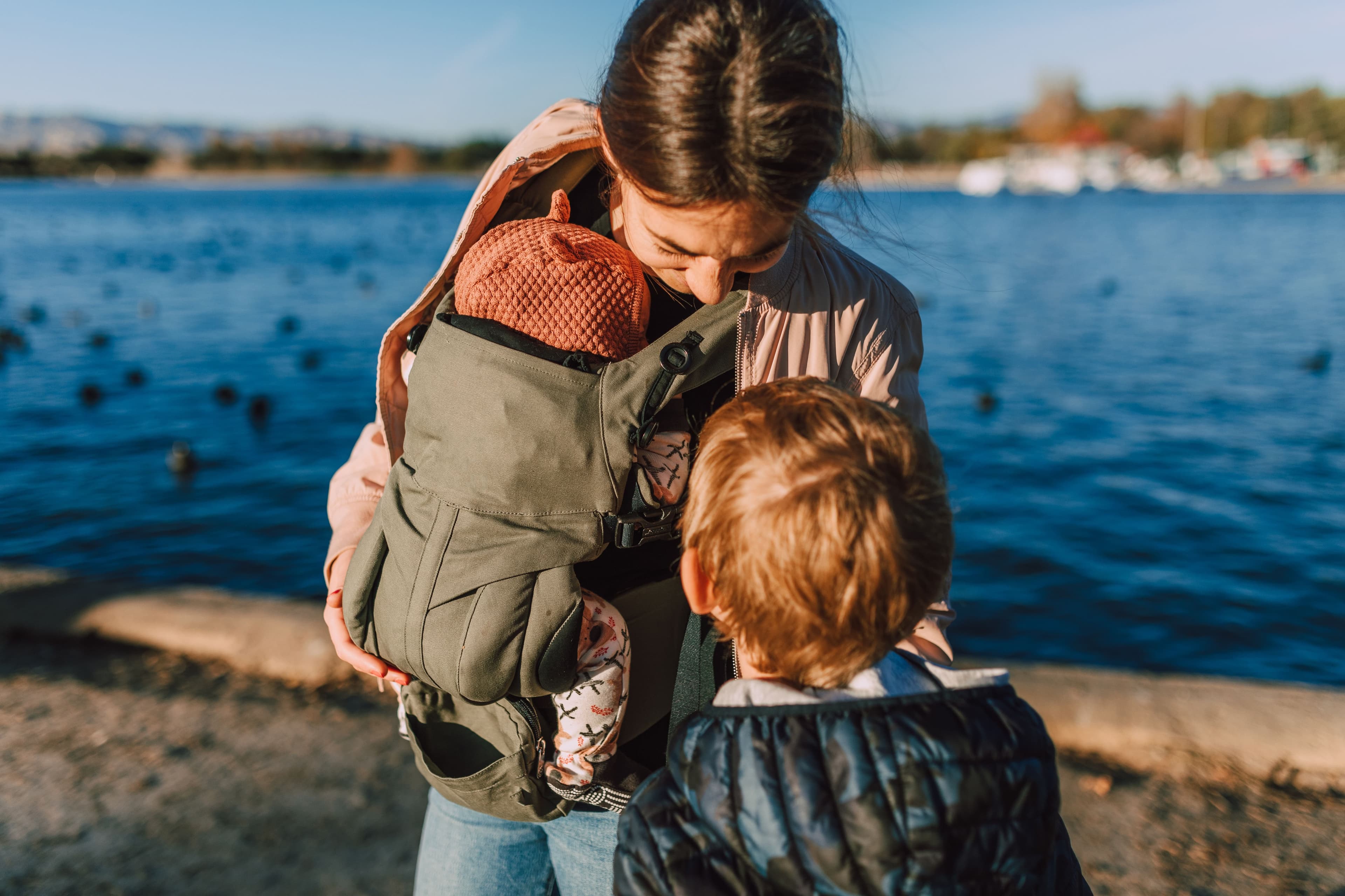 Parent wearing a baby in an ergonomic carrier — BabyCosts Australia