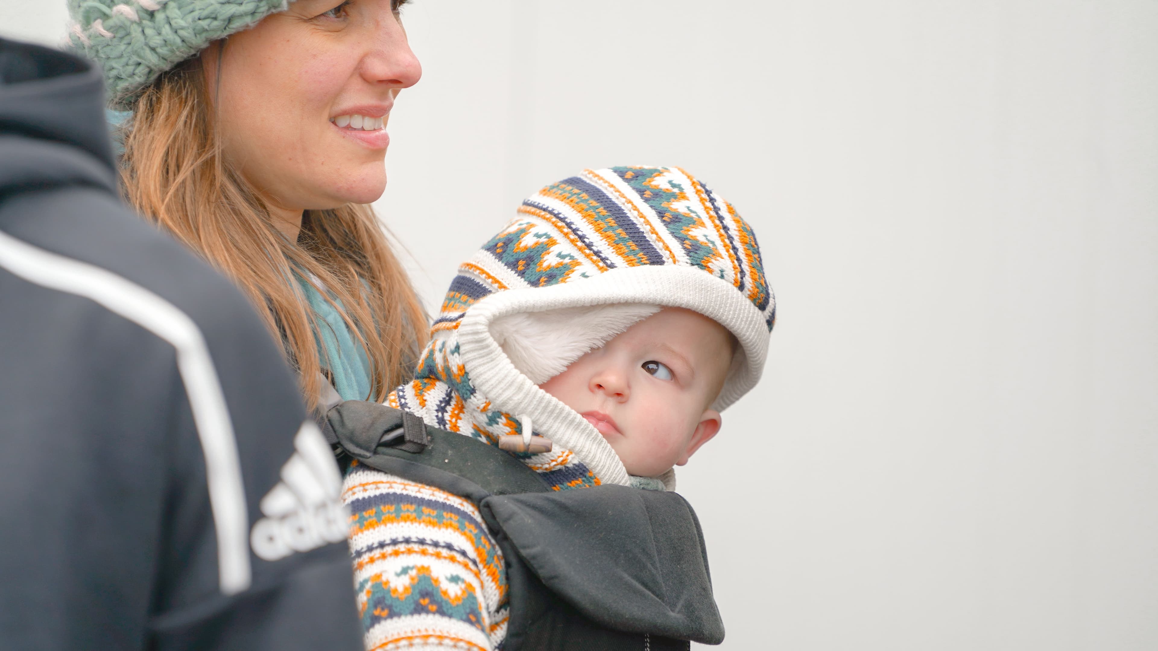 Parent wearing a baby in an ergonomic carrier — BabyCosts Australia