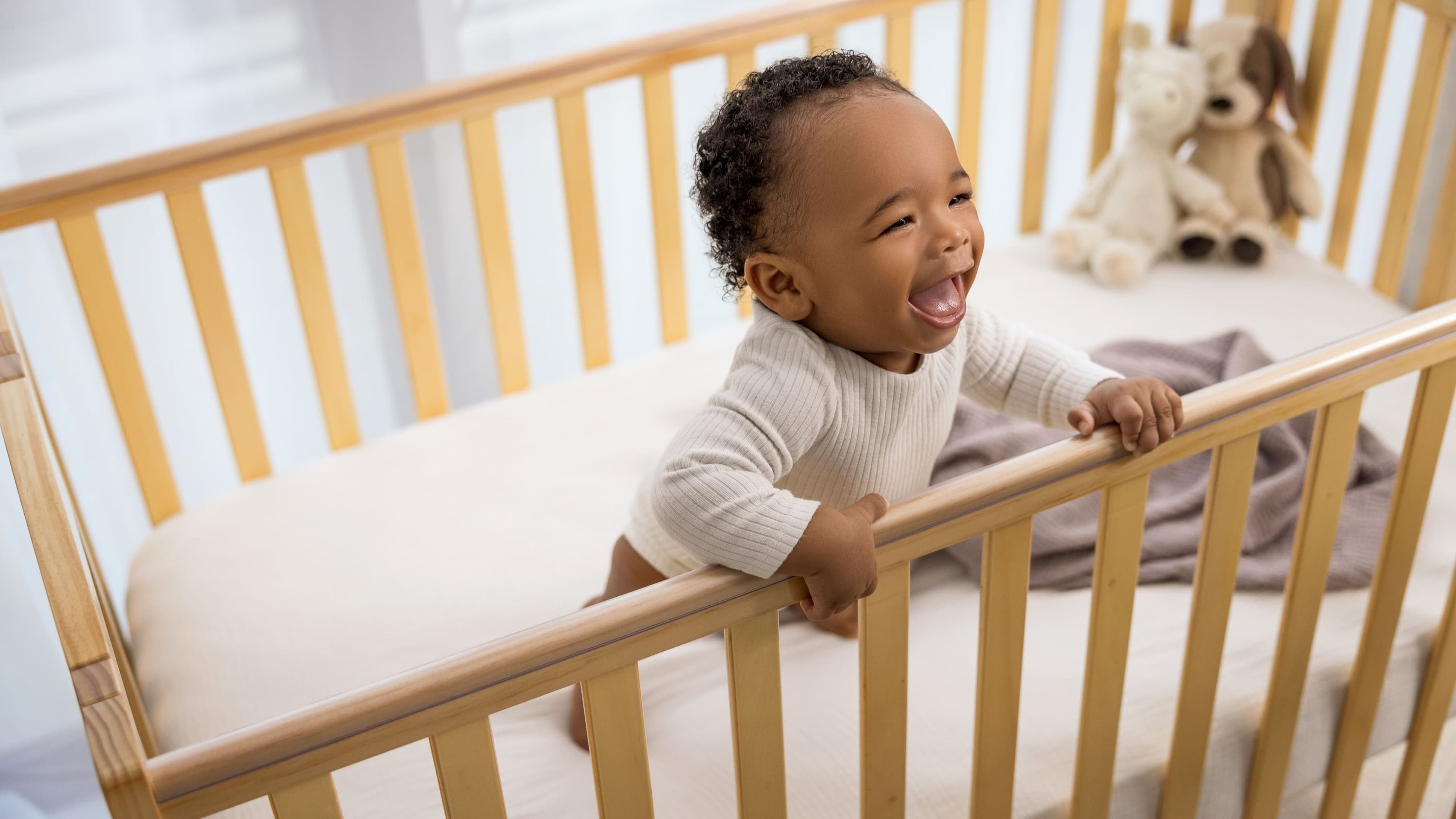Soft plush teddy bear hanging from a baby nursery mobile — BabyCosts Australia