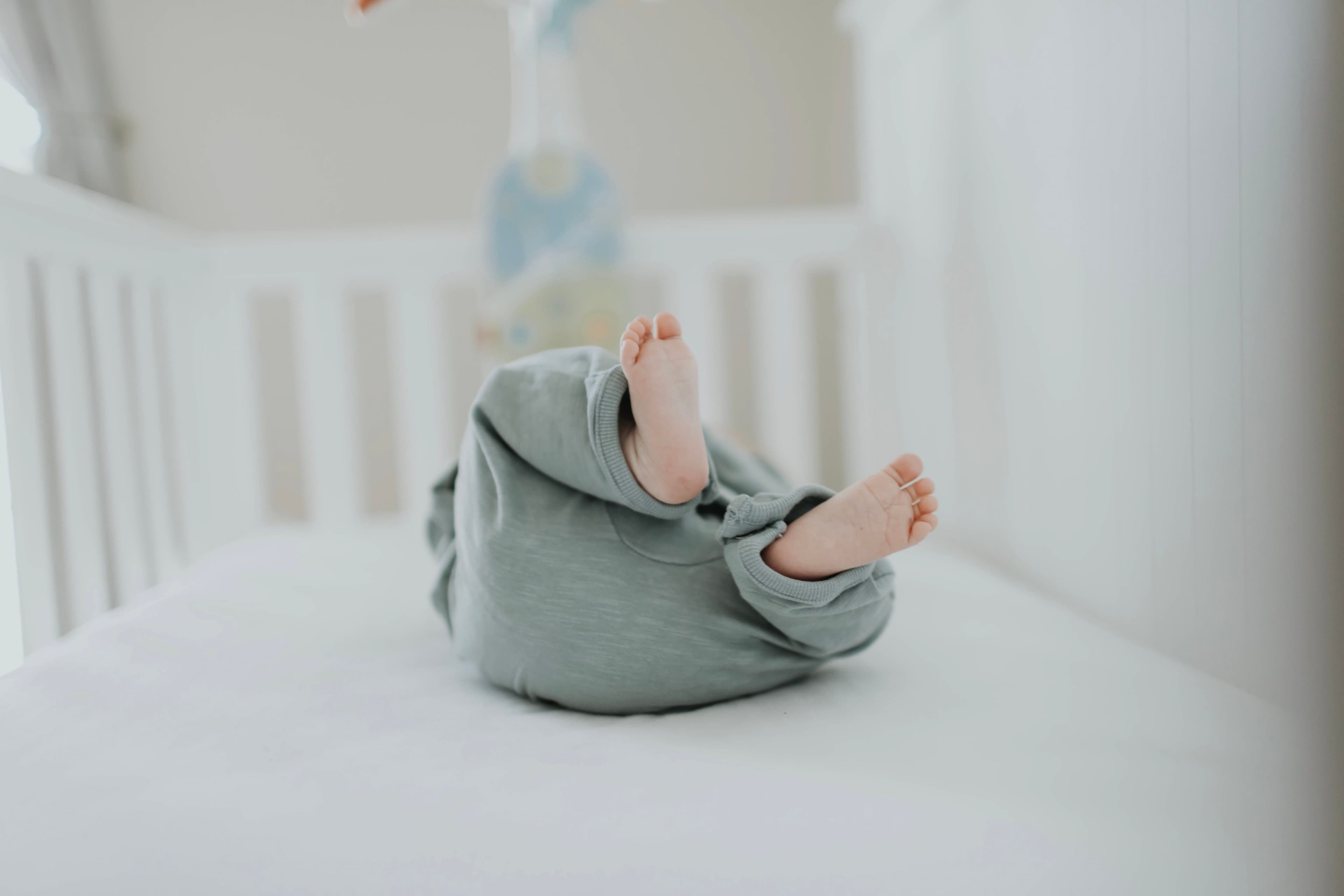 Soft plush teddy bear hanging from a baby nursery mobile — BabyCosts Australia