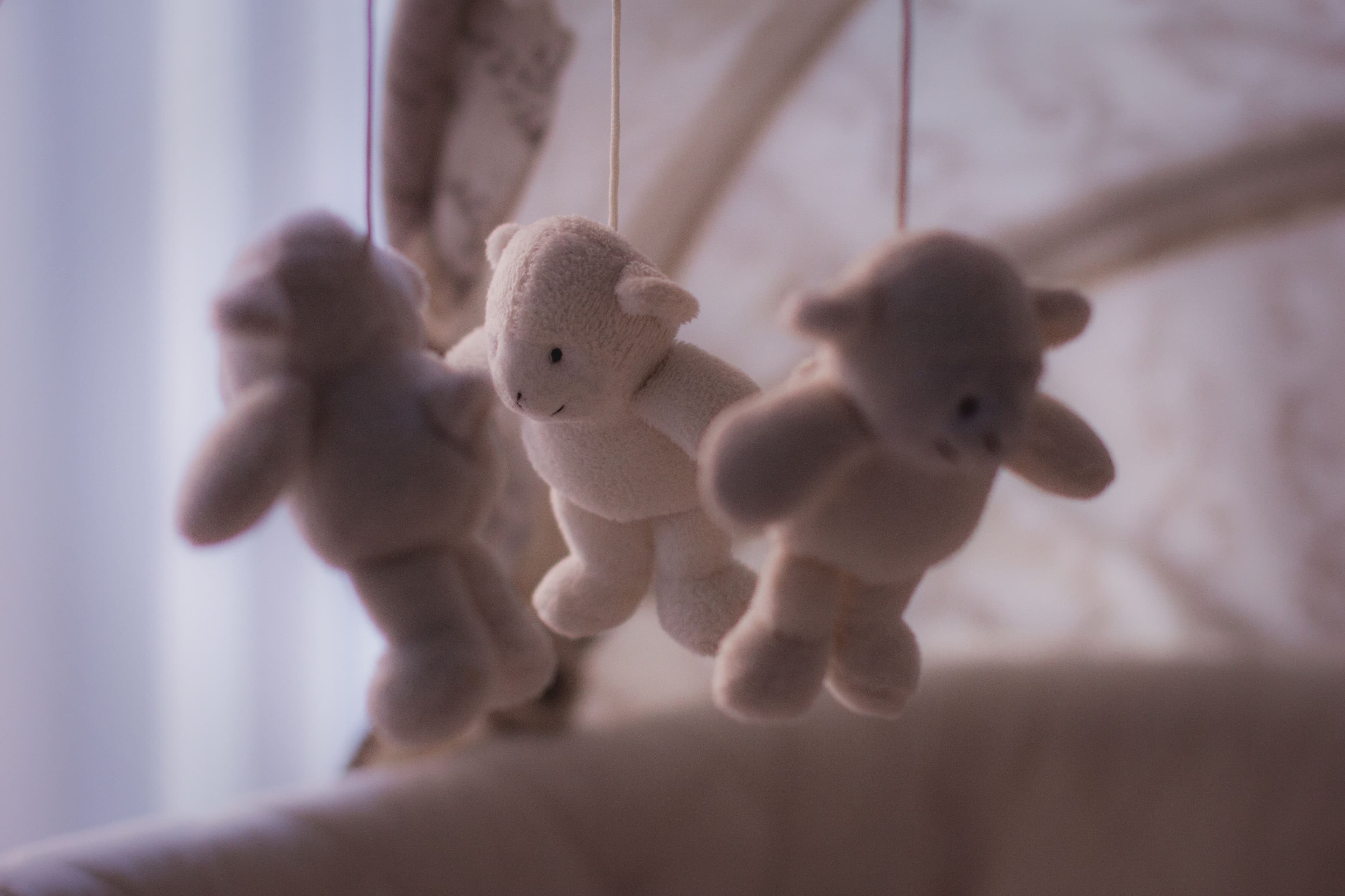 Soft plush teddy bear hanging from a baby nursery mobile β BabyCosts Australia