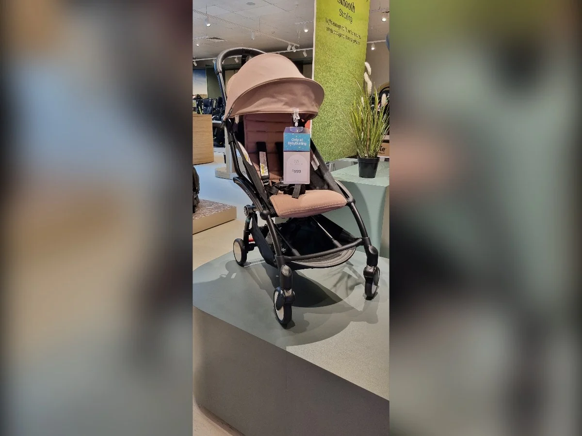 The Stokke YOYO³ ultra-lightweight travel pram folded to IATA cabin-baggage dimensions 52 × 44 × 18 cm, weighing only 6.1 kg, with perforated backrest and reflective wheels, designed to meet the AS/NZS 2088:2000 Australian pram standard, priced from $599 AUD at Australian retailers